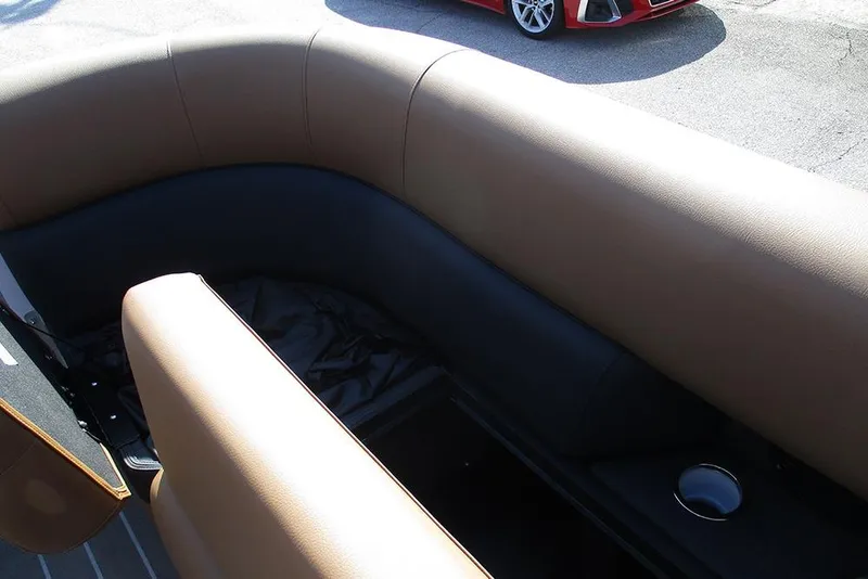 Slide: The Image of 2026 Bentley Pontoons Elite 253 interior seating with cup holder, featuring tan and black upholstery. - 18