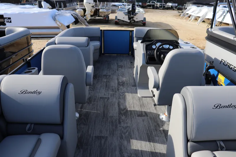 Slide: The Image of 2026 Bentley Pontoons Legacy 220 Navigator interior with gray seating and modern dashboard. - 9
