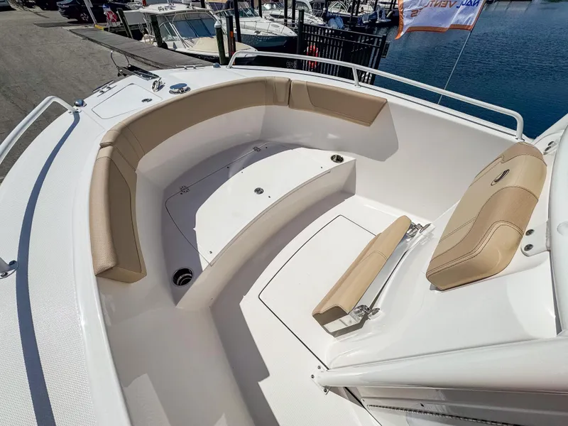 Slide: The Image of 2025 Edgewater 208CC boat interior with beige seating, docked at marina. - 17