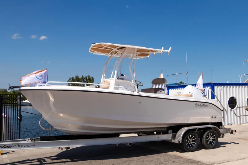 Slide: The Image of 2025 Edgewater 208CC boat on trailer, dockside, under clear blue sky. - 2