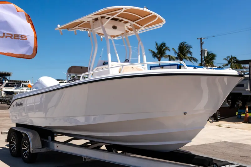 Slide: The Image of 2025 Edgewater 208CC boat on trailer, sunny day, palm trees in background. - 4