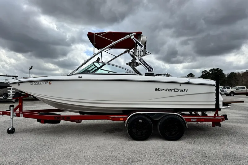 Slide: The Image of 2011 MasterCraft X25 boat on trailer under cloudy sky. - 7