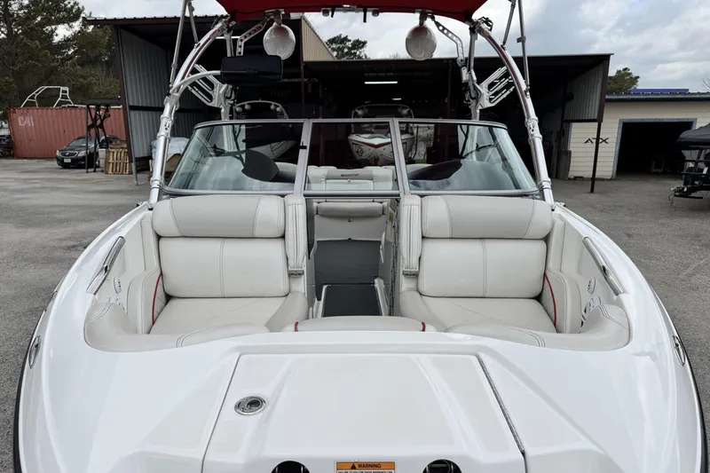 Slide: The Image of 2011 MasterCraft X25 boat with white interior, parked in a storage area. - 8