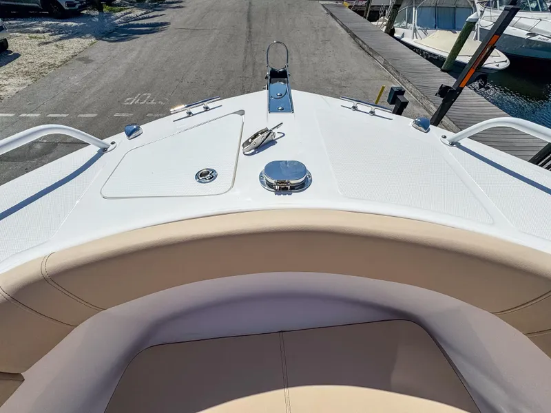 Slide: The Image of 2025 Edgewater 208CC boat bow with seating and deck details at a marina. - 19