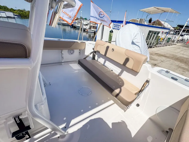 Slide: The Image of 2025 Edgewater 208CC boat interior with beige seating, docked at a marina. - 8