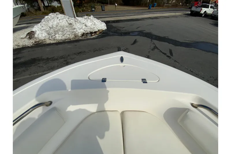 Slide: The Image of 2017 Tidewater 198 CC Adventure boat bow with seating, parked near snow pile. - 20