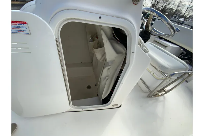 Slide: The Image of 2017 Tidewater 198 CC Adventure boat console storage area with open door. - 23