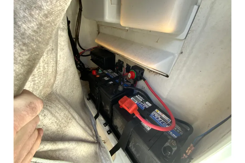 Slide: The Image of 2017 Tidewater 198 CC Adventure boat battery compartment with wiring and connections. - 24