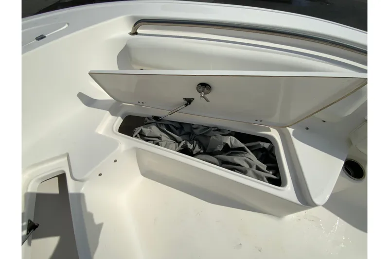 Slide: The Image of 2017 Tidewater 198 CC Adventure boat storage compartment with open lid and keys. - 29