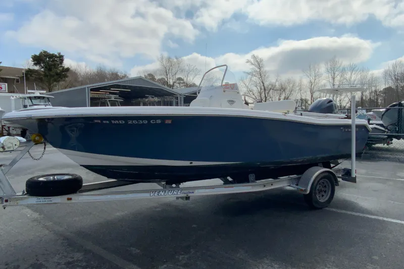 Slide: The Image of 2017 Tidewater 198 CC Adventure boat on trailer, parked outdoors under cloudy sky. - 5