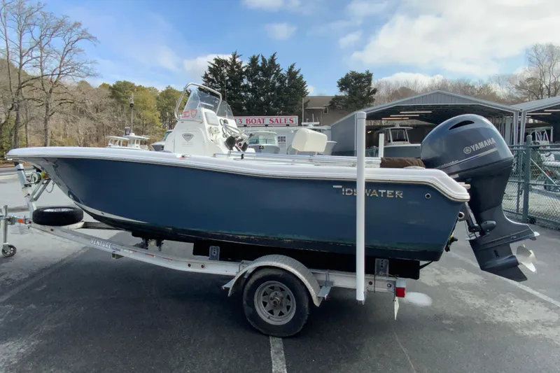 Slide: The Image of 2017 Tidewater 198 CC Adventure boat on trailer, parked outdoors near boat sales area. - 6