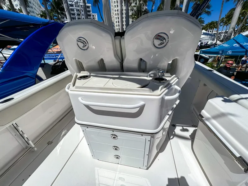 Slide: The Image of 2025 Edgewater 262CC boat interior with storage and seating, showcased outdoors. - 19