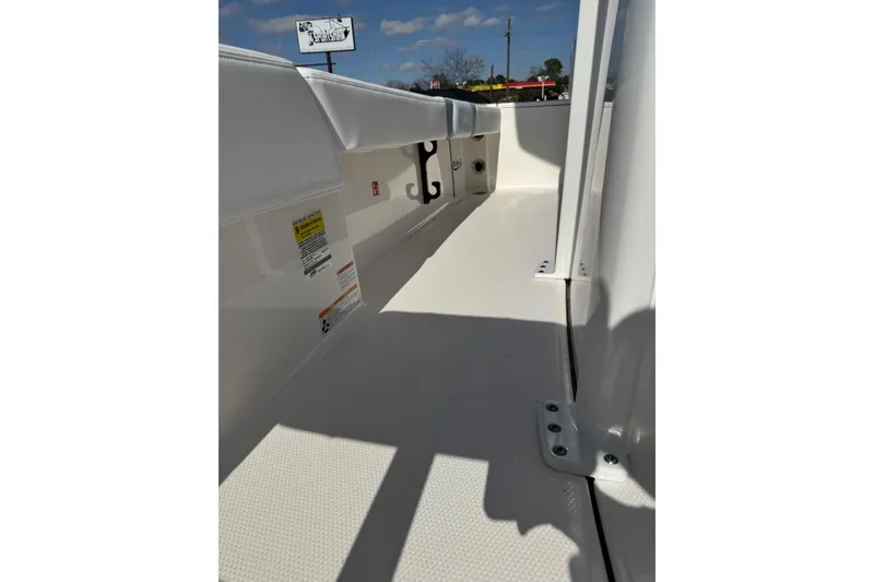 Slide: The Image of 2026 Robalo 246 Cayman boat interior with white seating and storage compartments. - 12