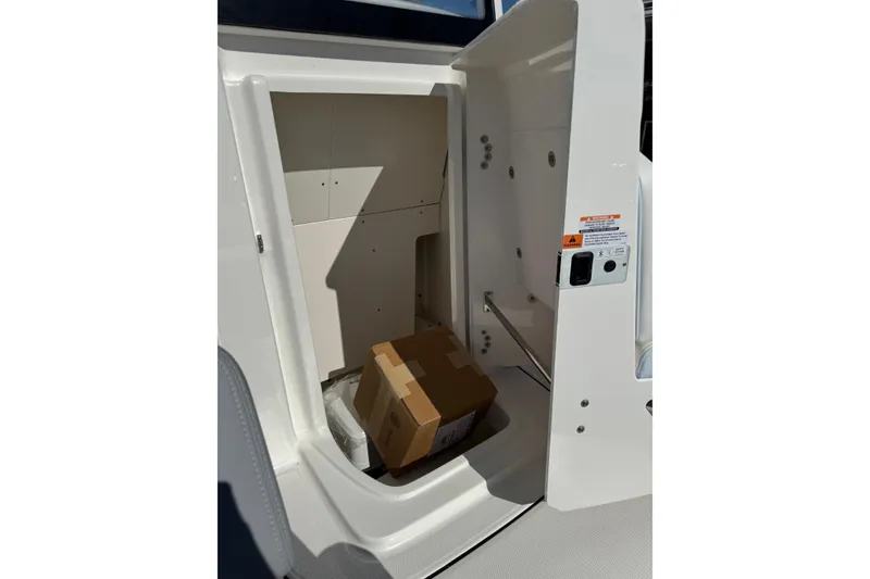 Slide: The Image of Storage compartment of 2026 Robalo 246 Cayman boat with cardboard box inside. - 14