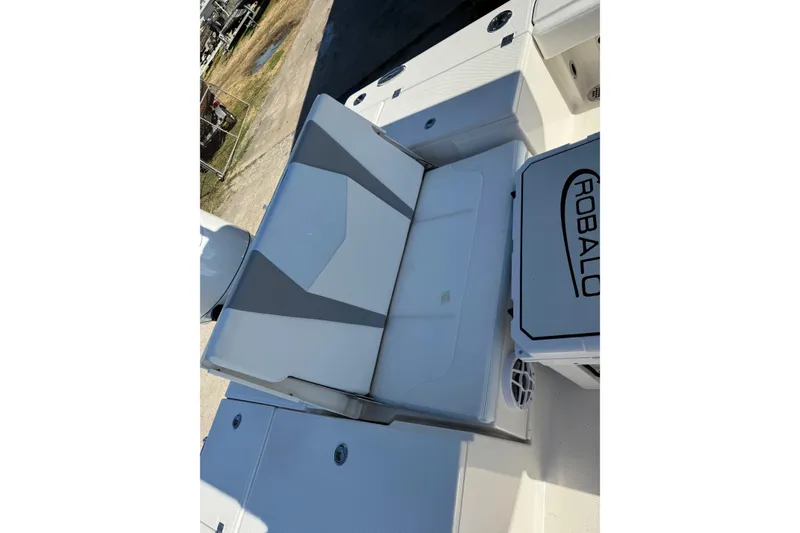 Slide: The Image of 2026 Robalo 246 Cayman boat interior with cushioned seating and storage compartment. - 22