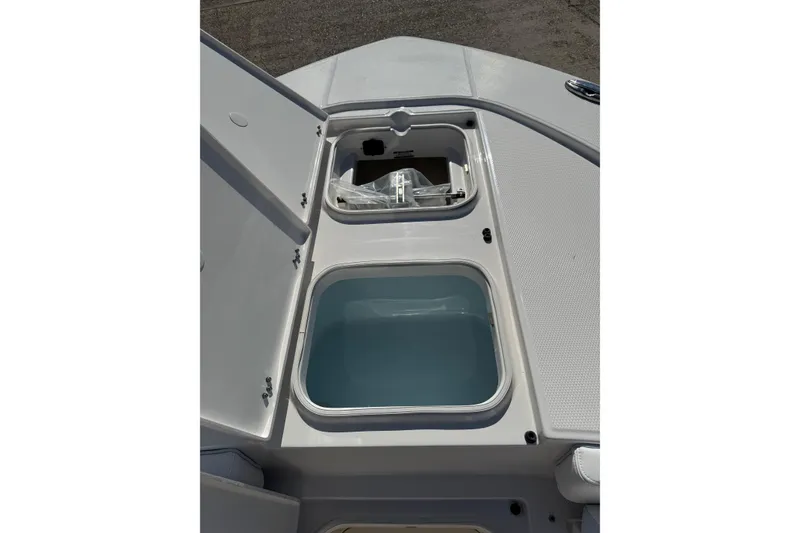Slide: The Image of 2026 Robalo 246 Cayman boat storage compartments with open lids, showcasing interior features. - 8