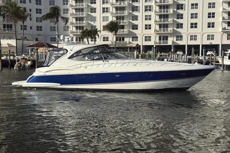 The Image of 2007 Cruisers Yachts 560 Express in marina, sleek design, blue and white exterior. - 0