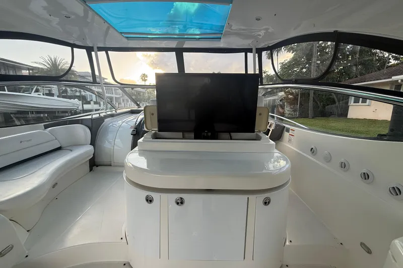 Slide: The Image of 2007 Cruisers Yachts 560 Express interior with seating and TV, featuring a sunroof. - 11
