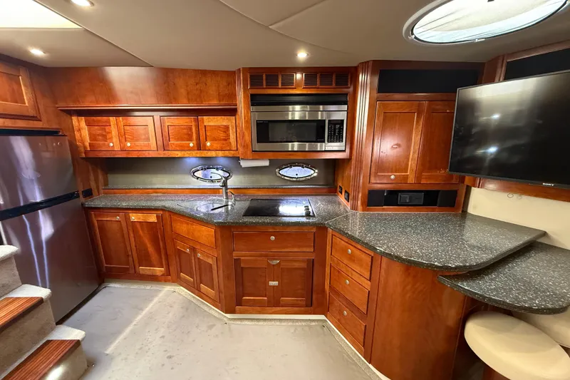 Slide: The Image of Luxurious 2007 Cruisers Yachts 560 Express kitchen with wood cabinetry and modern appliances. - 16
