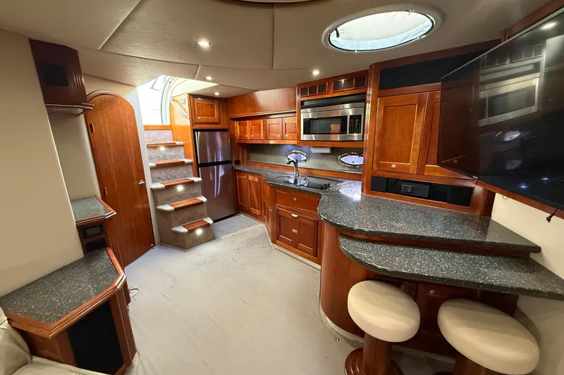 Slide: The Image of Luxurious 2007 Cruisers Yachts 560 Express interior with modern kitchen and elegant wood finishes. - 17