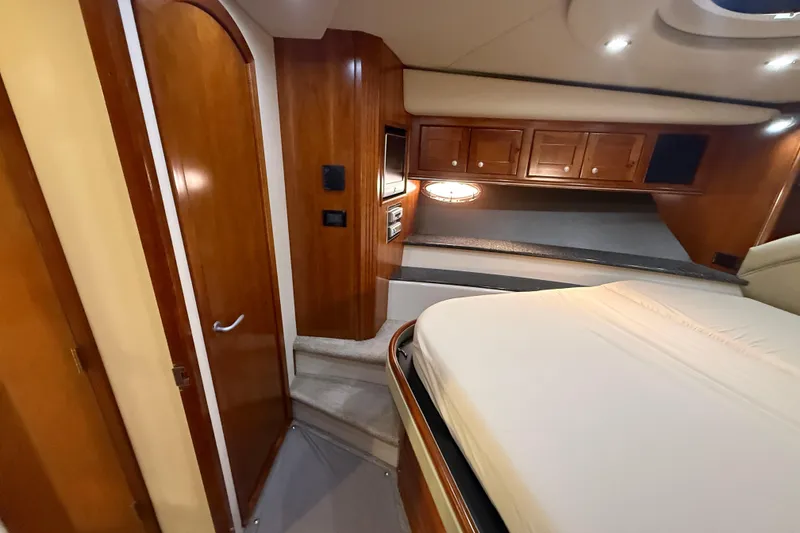 Slide: The Image of Luxurious 2007 Cruisers Yachts 560 Express cabin interior with wood finish and cozy bed. - 19