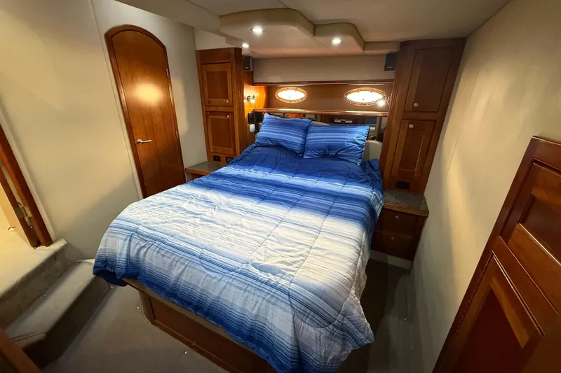 Slide: The Image of Luxurious bedroom interior of 2007 Cruisers Yachts 560 Express with blue bedding. - 22