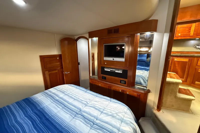 Slide: The Image of Luxurious 2007 Cruisers Yachts 560 Express cabin with wood accents and cozy bedding. - 23