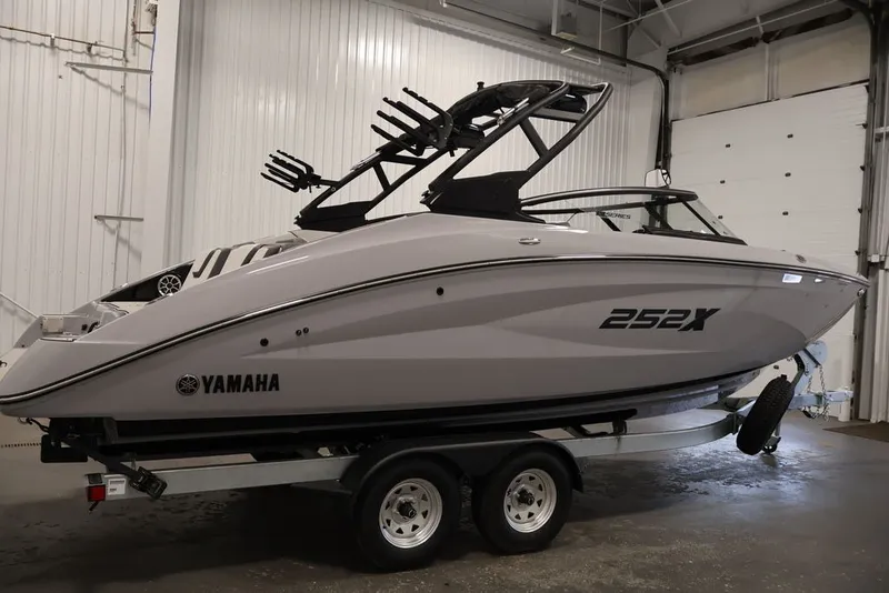 Slide: The Image of 2026 Yamaha Boats 252XE in a showroom, sleek design on a trailer. - 5