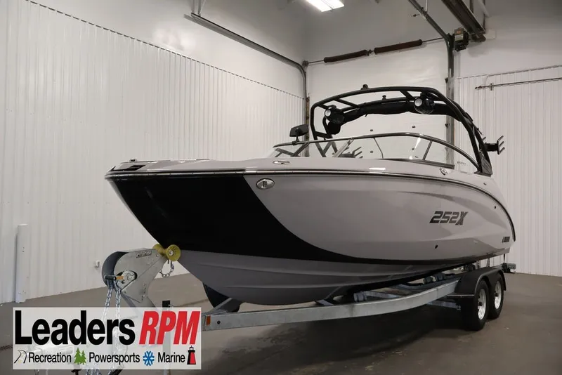 The Image of 2026 Yamaha Boats 252XE on trailer in indoor showroom setting. - 0