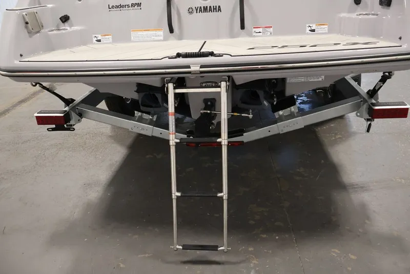 Slide: The Image of Rear view of 2026 Yamaha Boats 252XE with ladder and trailer attachment. - 30
