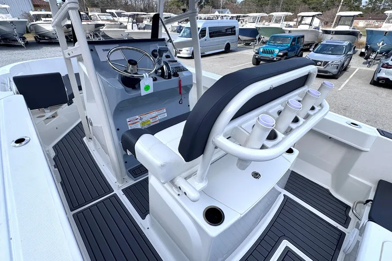 Slide: The Image of 2026 Trophy CC20 boat interior with steering console and rod holders in a marina setting. - 10