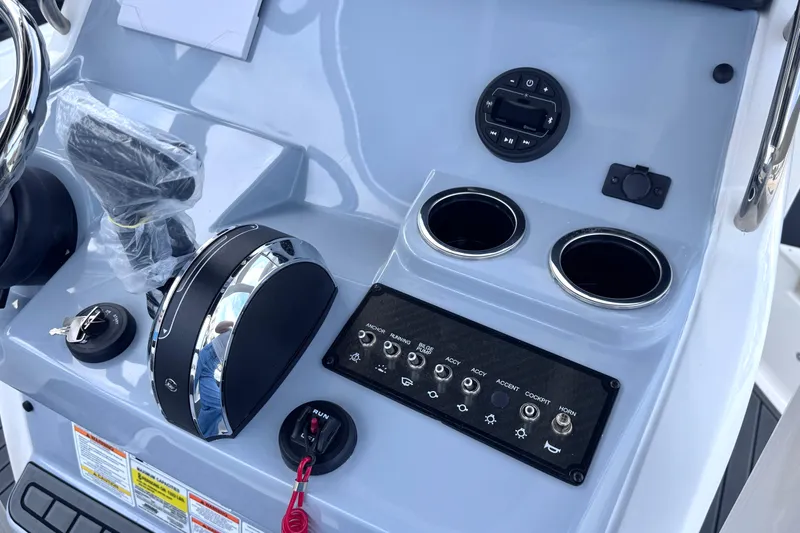 Slide: The Image of Control panel of 2026 Trophy CC20 boat with switches, cup holders, and ignition key. - 17