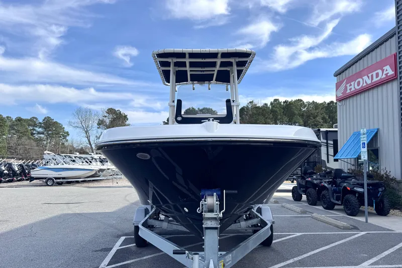 Slide: The Image of 2026 Trophy CC20 boat on trailer, parked near Honda dealership under blue sky. - 3