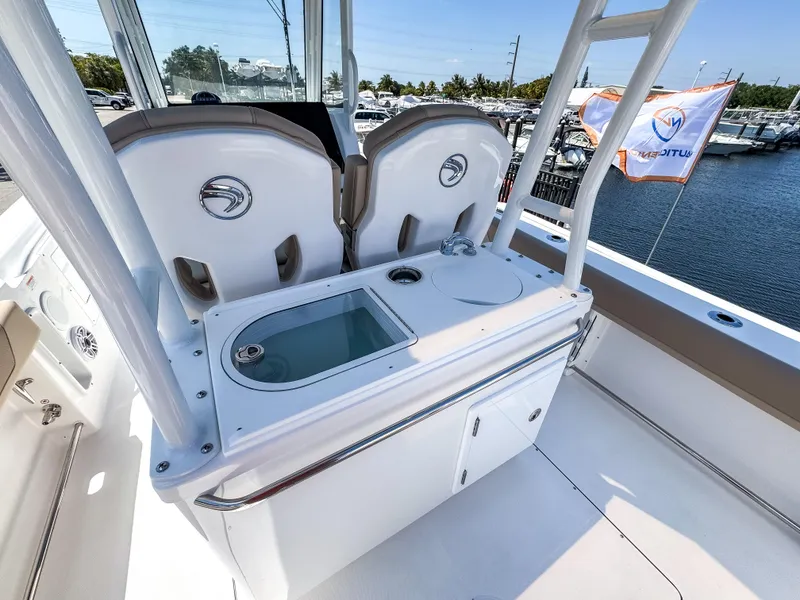 Slide: The Image of 2025 Edgewater 325CC boat interior with seating and storage, docked at marina. - 16