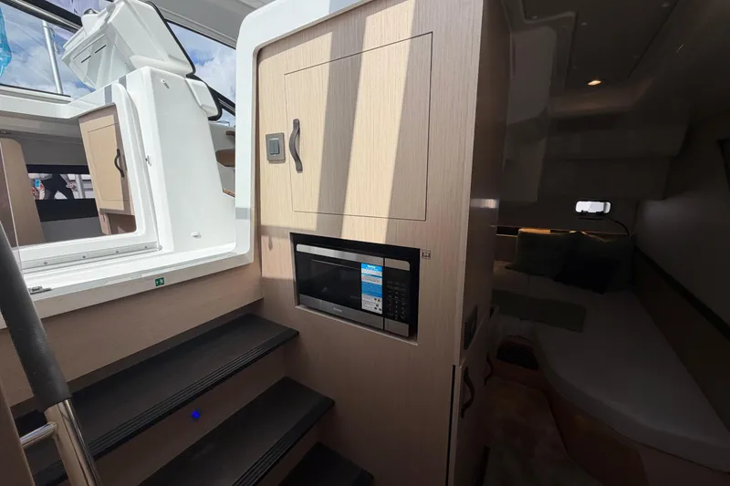 Slide: The Image of Interior of 2026 Jeanneau TH38 yacht with stairs, microwave, and cozy cabin. - 14