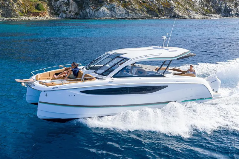 Slide: The Image of Manufacturer Provided Image: 2026 Jeanneau TH38 cruising on clear blue waters near rocky coastline. - 4