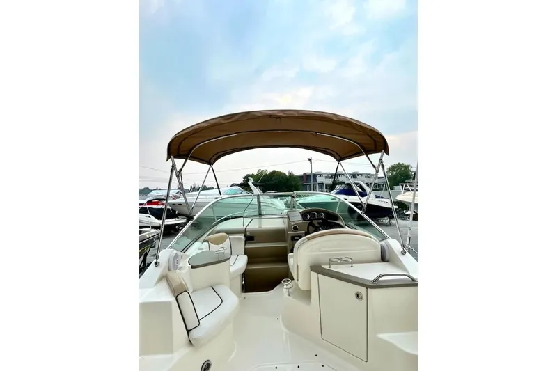Slide: The Image of 2008 Sea Ray 240 Sundancer boat interior with canopy, steering wheel, and seating area. - 7