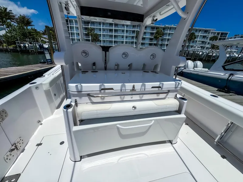 Slide: The Image of 2025 Edgewater 370CC boat interior with seating and storage, docked near waterfront buildings. - 10