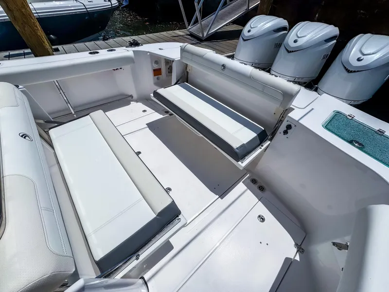 Slide: The Image of 2025 Edgewater 370CC boat interior with white seating and triple outboard engines. - 13