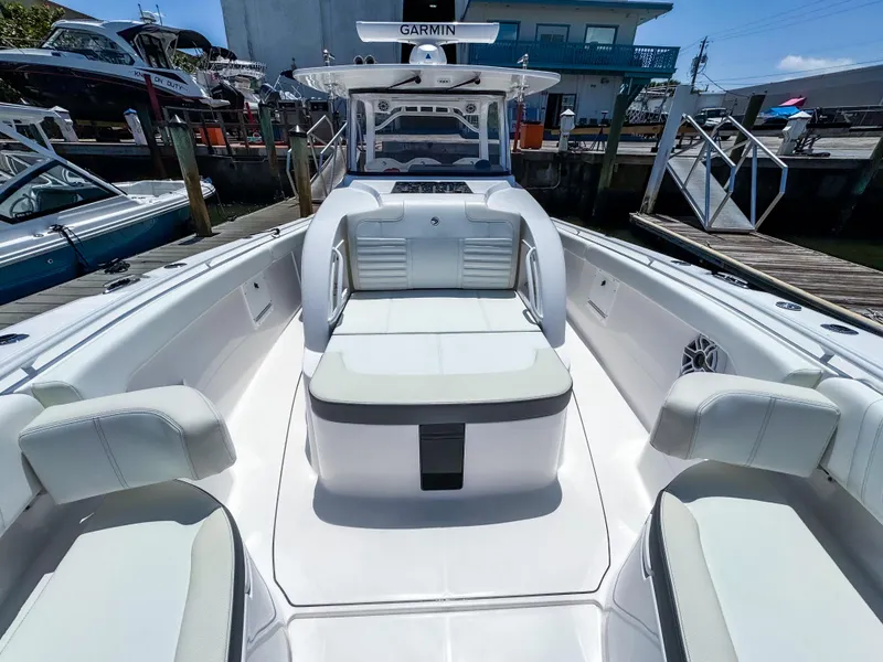 Slide: The Image of 2025 Edgewater 370CC boat with spacious seating and Garmin navigation system at a marina. - 28