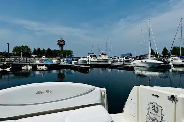 Slide: The Image of 2001 Sea Ray 380 Sundancer in marina, calm waters, clear sky, boats docked nearby. - 12