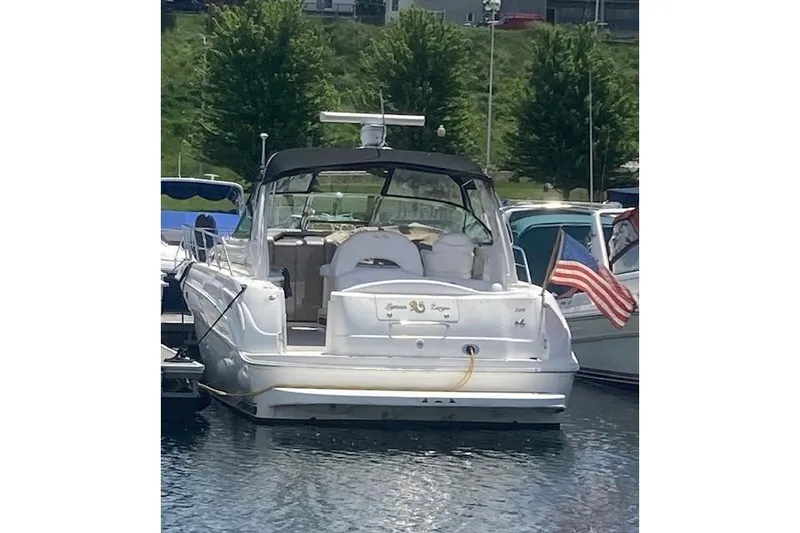 Slide: The Image of 2001 Sea Ray 380 Sundancer docked with American flag, lush greenery in background. - 13