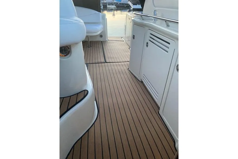 Slide: The Image of 2001 Sea Ray 380 Sundancer boat deck with sleek wood finish and white cabinetry. - 16