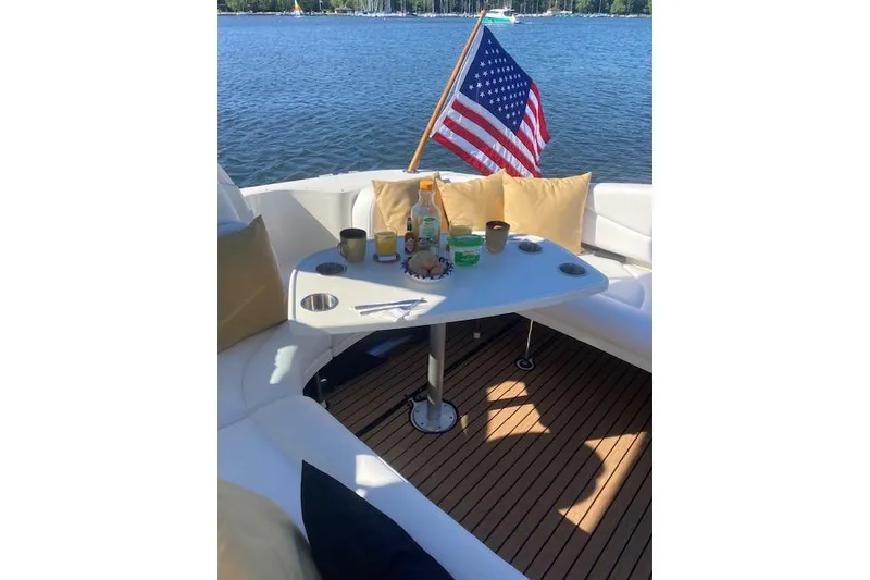 Slide: The Image of Cozy seating area on 2001 Sea Ray 380 Sundancer with American flag and refreshments. - 18