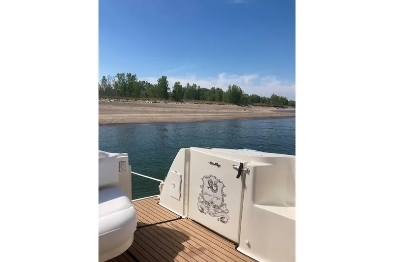 Slide: The Image of 2001 Sea Ray 380 Sundancer yacht on calm water near a sandy shore. - 23