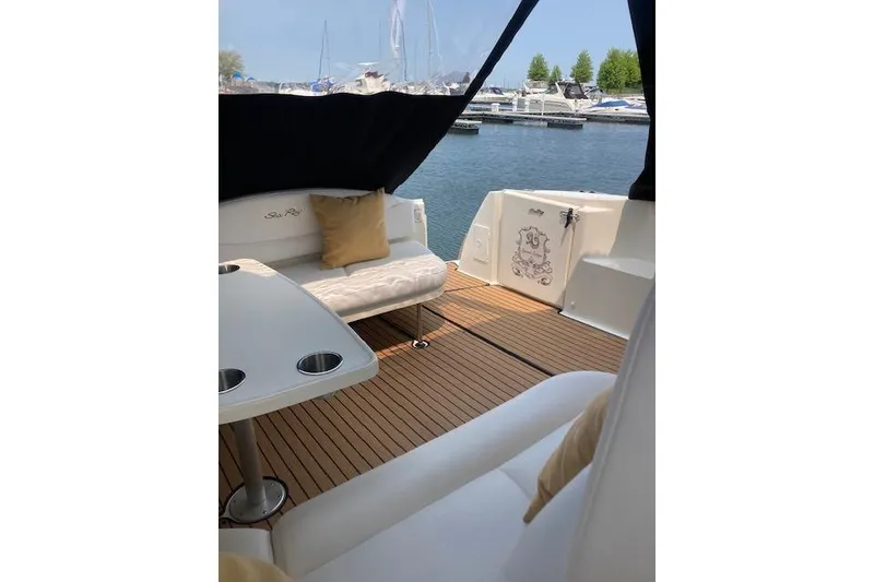 Slide: The Image of 2001 Sea Ray 380 Sundancer yacht interior with seating and table, docked at marina. - 26
