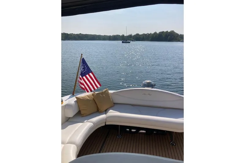 Slide: The Image of 2001 Sea Ray 380 Sundancer yacht with American flag on serene lake. - 28