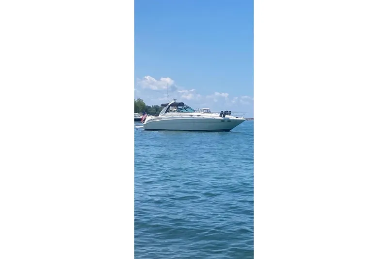 Slide: The Image of 2001 Sea Ray 380 Sundancer yacht on calm blue water under clear sky. - 31