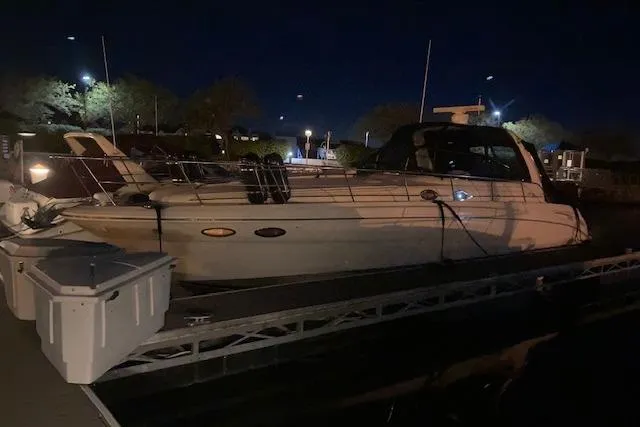 Slide: The Image of 2001 Sea Ray 380 Sundancer yacht docked at night, illuminated by nearby lights. - 34