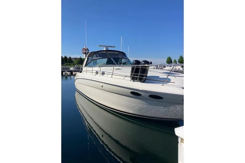 Slide: The Image of 2001 Sea Ray 380 Sundancer yacht docked in a marina under clear blue skies. - 35